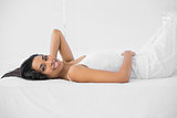 Lovely smiling woman posing lying on her bed