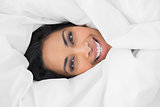 Content beautiful woman lying under cover on her bed