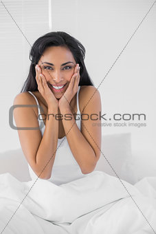 Gleeful dark haired woman posing smiling at camera