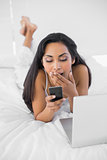 Calm yawning woman text messaging with her smartphone