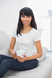 Lovely smiling woman holding a cup smiling at camera