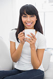 Calm beautiful woman holding a cup smiling at camera