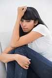 Thinking calm woman sitting on couch
