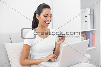 Content woman home shopping with her notebook