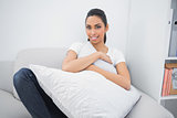 Sweet casual woman holding a pillow while lying on couch