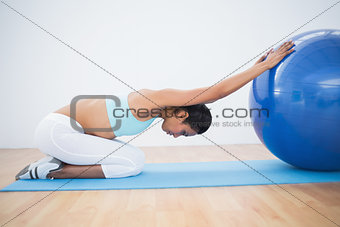 Lovely toned woman stretching her body with exercise ball