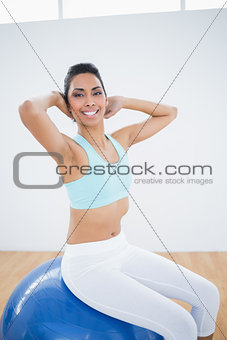 Sporty woman stretching sitting on fitness ball