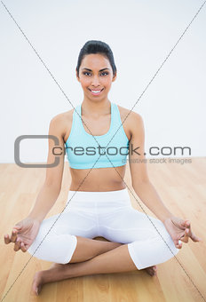 Beautiful slender woman meditating in lotus position