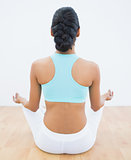 Rear view of slender calm woman meditating in lotus position