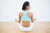 Rear view of calm woman meditating in lotus position