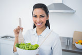 Beautiful smiling woman showing salad smiling at camera