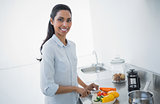 Attractive black haired woman preparing salad