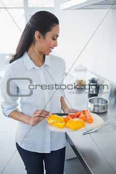 Cute happy woman holding tray with vegetables