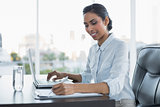 Content smiling businesswoman working sitting at her desk