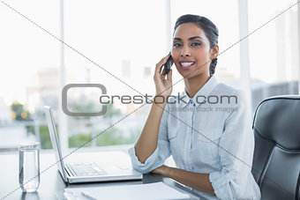 Young black haired businesswoman sitting at her desk