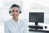 Attractive female agent wearing headset smiling at camera