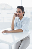 Beautiful calm businesswoman sitting thoughtful at desk