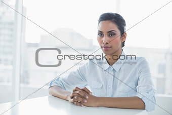 Serious classy businesswoman sitting at her desk
