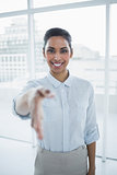 Content smiling businesswoman reaching her hand