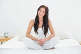 Woman sitting and smiling in bed