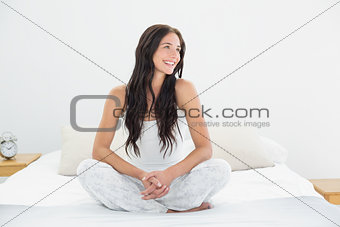 Smiling woman looking away in bed
