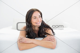 Smiling woman looking away in bed