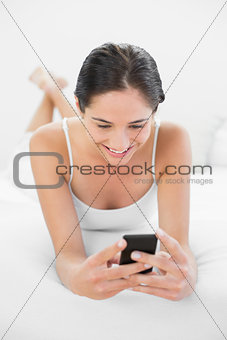 Relaxed woman with mobile phone in bed