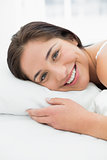 Smiling young woman resting in bed