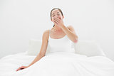 Young woman yawning in bed