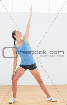 Sporty woman stretching hand in fitness center