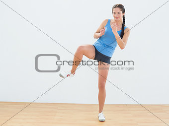 Sporty woman stretching leg in fitness center