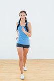 Sporty woman in jogging posture at fitness center