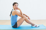 Portrait of a fit woman sitting upright on exercise mat