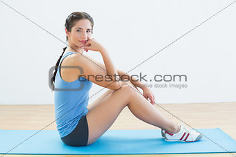 Portrait of a fit woman sitting upright on exercise mat