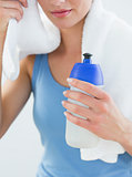 Woman with towel around neck and waterbottle