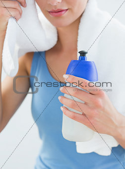 Woman with towel around neck and waterbottle