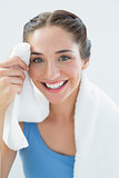Close up of a smiling woman wiping sweat with towel