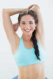 Sporty woman stretching hands behind back
