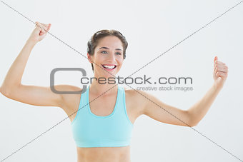 Cheerful sporty woman with clenched fists