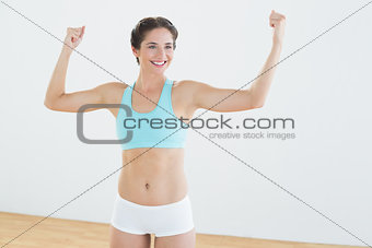 Fit woman in sportswear standing with clenched fists