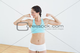 Fit young woman flexing muscles
