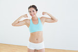Fit woman flexing muscles in fitness studio