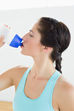 Close up of a fit woman drinking water at the gym