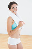 Fit woman with towel around neck at fitness studio