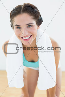 Smiling woman with towel around neck at fitness studio