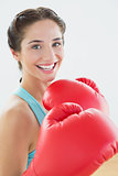 Close up portrait of a beautiful smiling woman in red boxing gloves