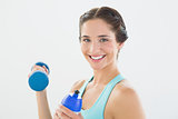 Woman with dumbbells and water bottle over white background