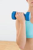 Mid section Close up of a woman with dumbbells at fitness studio