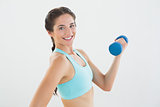 Side view portrait of a smiling woman with dumbbell