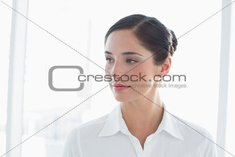 Thoughtful young business woman looking away